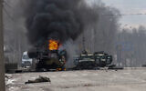 A Russian armored personnel carrier burns amid damaged and abandoned light utility vehicles after fighting in Kharkiv, Ukraine, Feb. 27, 2022. (AP Photo/Marienko Andrew, File)
