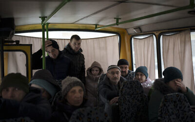 Ukrainians enter a bus as they are evacuated from Irpin, on the outskirts of Kyiv, Ukraine,March 9, 2022. (AP Photo/Felipe Dana)