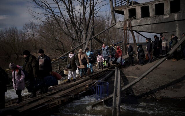 Ukrainians cross an improvised path under a destroyed bridge while fleeing Irpin, on the outskirts of Kyiv, Ukraine, on March 9, 2022. (AP Photo/Felipe Dana) Ukrainians cross an improvised path under a destroyed bridge while fleeing Irpin, on the outskirts of Kyiv, Ukraine, on March 9, 2022. (AP Photo/Felipe Dana)