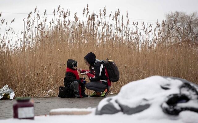 Tatiana Kostyuk, 38, from Zaporozhye, gives food to a child after fleeing Ukraine, at the border crossing in Medyka, Poland, March 9, 2022 (AP Photo/Visar Kryeziu) Tatiana Kostyuk, 38, from Zaporozhye, gives food to a child after fleeing Ukraine, at the border crossing in Medyka, Poland, March 9, 2022 (AP Photo/Visar Kryeziu)