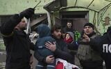 A man carries his child away from the Russian-bombarded maternity hospital in Mariupol, Ukraine, Wednesday, March 9, 2022. (AP Photo/Evgeniy Maloletka)