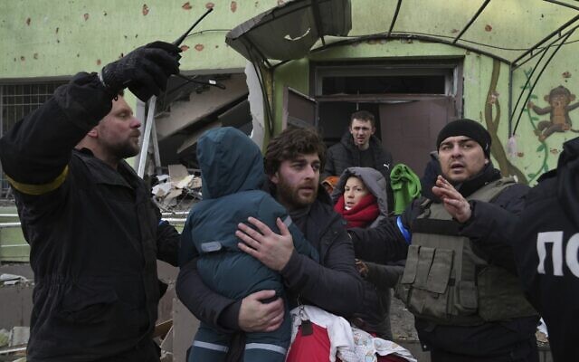 A man carries his child away from the Russian-bombarded maternity hospital in Mariupol, Ukraine, Wednesday, March 9, 2022. (AP Photo/Evgeniy Maloletka)