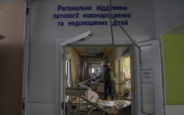 A volunteer works inside of the damaged by shelling maternity hospital in Mariupol, Ukraine, Wednesday, March 9, 2022. (AP Photo/Evgeniy Maloletka)