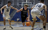 Yeshiva University's Ryan Turell (11) dribbles the ball down court while being defended by Johns Hopkins University's Carson James (21) and Lincoln Yeutter (25) in the first round of the NCAA's Division III basketball tournament, in Galloway Township, New Jersey, March 4, 2022. (AP Photo/Jessie Wardarski)