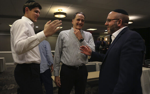 Yeshiva Maccabees' Gabriel Leifer, left, talks with men's basketball assistant coaches Joseph Schwartz and Yoni Cohen at the conclusion of Shabbat on Saturday, March 5, 2022, at the Seaview Hotel in Galloway Township, N.J. (AP Photo/Jessie Wardarski)