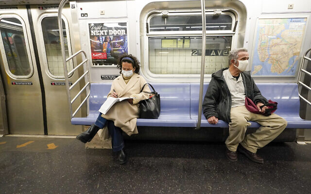 Commuters wear face masks and social distance while riding an M Train, on March 9, 2021, in New York's subway system. (AP Photo/Mary Altaffer, File) Commuters wear face masks and social distance while riding an M Train, on March 9, 2021, in New York's subway system. (AP Photo/Mary Altaffer, File)