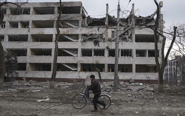 A man walks with a bicycle in front of a damaged by shelling in Mariupol, Ukraine, March 10, 2022. (AP Photo/Evgeniy Maloletka) A man walks with a bicycle in front of a damaged by shelling in Mariupol, Ukraine, March 10, 2022. (AP Photo/Evgeniy Maloletka)