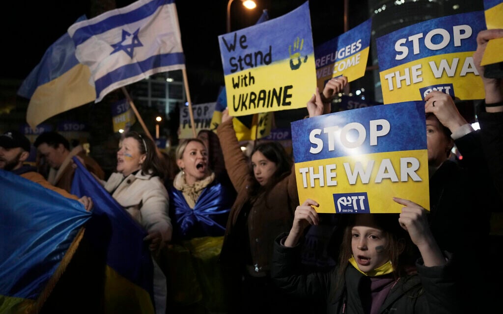 People hold placards as they take part in a protest against the Russian invasion of Ukraine, outside government office in Tel Aviv, March 12, 2022. (AP/Ariel Schalit) People hold placards as they take part in a protest against the Russian invasion of Ukraine, outside government office in Tel Aviv, March 12, 2022. (AP/Ariel Schalit)