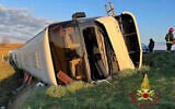 A bus that was reportedly carrying Ukranian refugees lies on its side after overturning near Forli, Italy, March 13, 2022. (Vigili del Fuoco via AP)