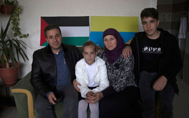 Ukrainian Oksana al-Astal sits with her Palestinian husband and their children as they pose for a photo in front of Palestinian and Ukrainian flags decorating the living room of their home in Khan Younis, southern Gaza Strip, March 13, 2022. (AP Photo/ Khalil Hamra) Ukrainian Oksana al-Astal sits with her Palestinian husband and their children as they pose for a photo in front of Palestinian and Ukrainian flags decorating the living room of their home in Khan Younis, southern Gaza Strip, March 13, 2022. (AP Photo/ Khalil Hamra)