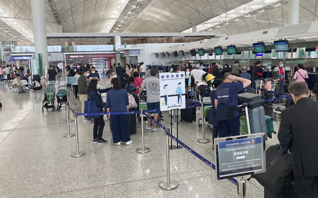 In a mostly empty departure lounge usually bustling with travelers, a long line of travelers wait to check in for a single flight to Singapore at the International airport in Hong Kong, March 14, 2022. (AP Photo/YK Chan) In a mostly empty departure lounge usually bustling with travelers, a long line of travelers wait to check in for a single flight to Singapore at the International airport in Hong Kong, March 14, 2022. (AP Photo/YK Chan)