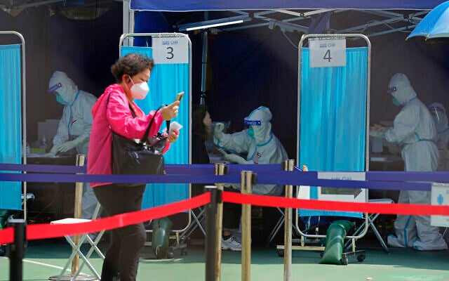 Medical workers help residents to get tested for the coronavirus at a temporary testing center in Hong Kong, March 14, 2022. (AP Photo/Kin Cheung) Medical workers help residents to get tested for the coronavirus at a temporary testing center in Hong Kong, March 14, 2022. (AP Photo/Kin Cheung)