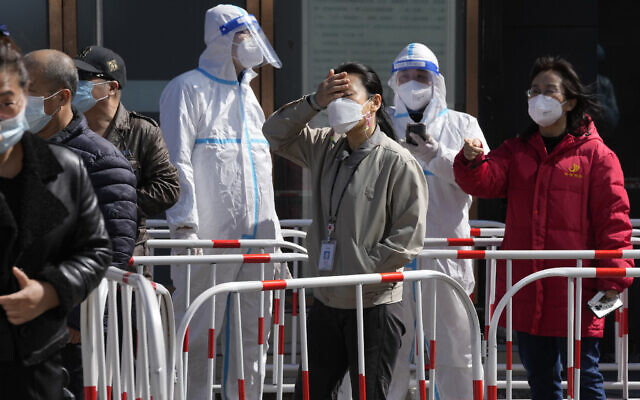 Workers line up for COVID test outside an office building on March 14, 2022, in Beijing (AP Photo/Ng Han Guan)