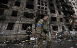 Ukrainian soldiers and firefighters search in a destroyed building after a bombing attack in Kyiv, Ukraine, March 14, 2022. (AP Photo/Vadim Ghirda)