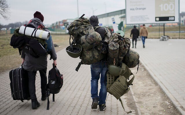 A man carries combat gear as he leaves Poland to fight in Ukraine, at the border crossing in Medyka, Poland, March 2, 2022. (AP Photo/Markus Schreiber) A man carries combat gear as he leaves Poland to fight in Ukraine, at the border crossing in Medyka, Poland, March 2, 2022. (AP Photo/Markus Schreiber)