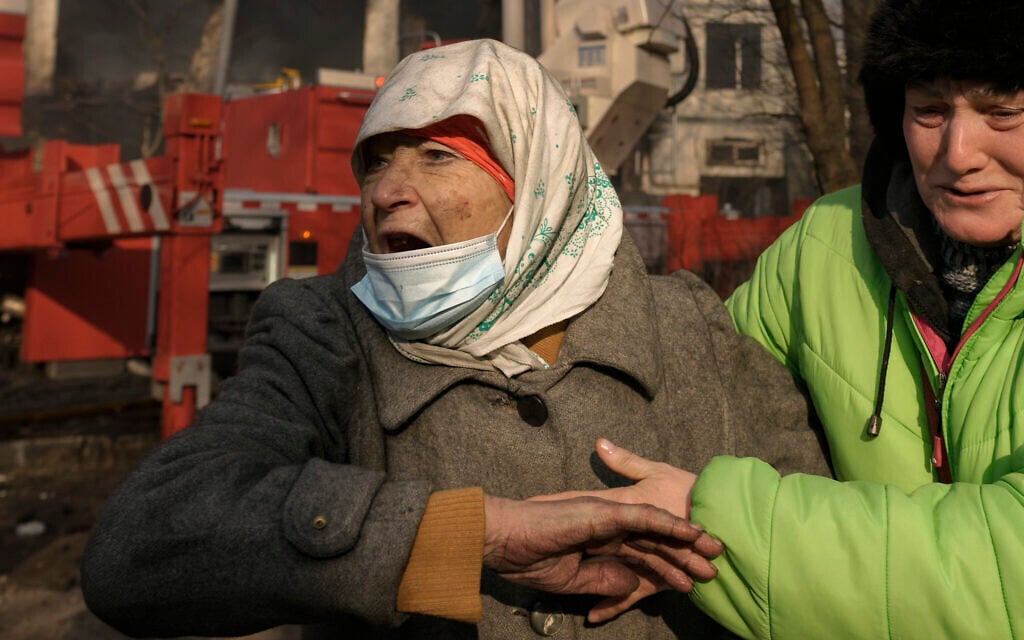 Women cry outside a destroyed apartment building after a bombing in a residential area in Kyiv, Ukraine, Tuesday, March 15, 2022.  (AP Photo/Vadim Ghirda)