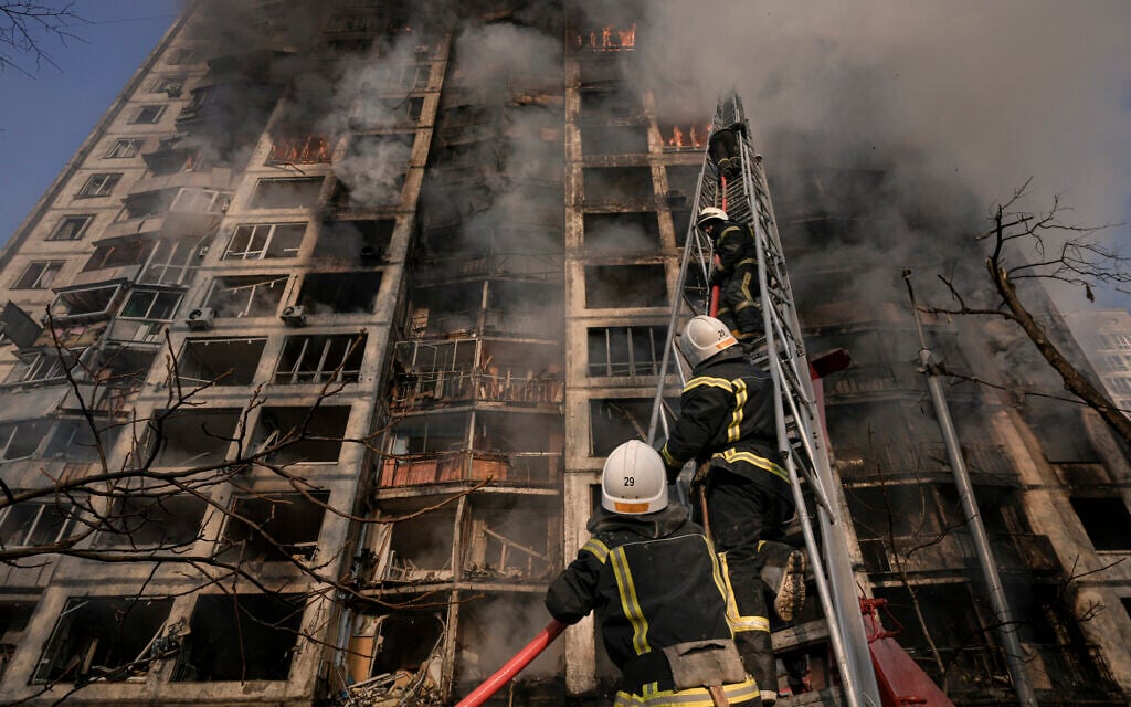 Firefighters climb a ladder while working to extinguish a blaze in a destroyed apartment building after a bombing in a residential area in Kyiv, Ukraine, on Tuesday, March 15, 2022. (AP/Vadim Ghirda)
