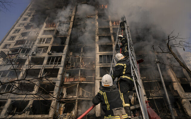Firefighters climb a ladder while working to extinguish a blaze in a destroyed apartment building after a bombing in a residential area in Kyiv, Ukraine, on Tuesday, March 15, 2022. (AP/Vadim Ghirda)