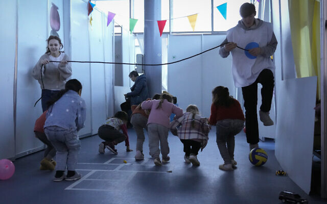 Volunteers entertain children who fled the war in Ukraine at the refugee camp at MoldExpo national exhibition center in Chisinau, Moldova, Monday, March 14, 2022. (AP Photo/Sergei Grits) Volunteers entertain children who fled the war in Ukraine at the refugee camp at MoldExpo national exhibition center in Chisinau, Moldova, Monday, March 14, 2022. (AP Photo/Sergei Grits)