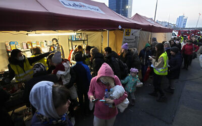 Ukrainian refugees pick up donated food and hygiene and bayby care products at the Warsaw Centralna train station, in Poland, March 16, 2022. (Czarek Sokolowski/AP)