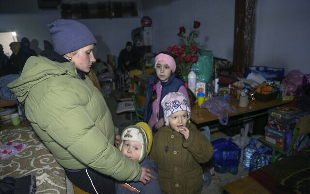 A woman and children shield from shelling in a school bomb shelter in Sartana village which is under the Government of the Donetsk People's Republic control, 17 kilometers (11 miles) northeast of Mariupol, eastern Ukraine, March 16, 2022. (AP Photo/Alexei Alexandrov) A woman and children shield from shelling in a school bomb shelter in Sartana village which is under the Government of the Donetsk People's Republic control, 17 kilometers (11 miles) northeast of Mariupol, eastern Ukraine, March 16, 2022. (AP Photo/Alexei Alexandrov)