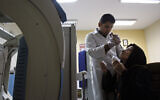 In this Oct. 11, 2010, file photo, Iranian nuclear medicine Kouhyar Gervand, drops technetium-99 into eyes of Zahra Kohanmanesh, for her eye scan, at the Shariati hospital, in Tehran, Iran.  (AP Photo/Vahid Salemi, File)