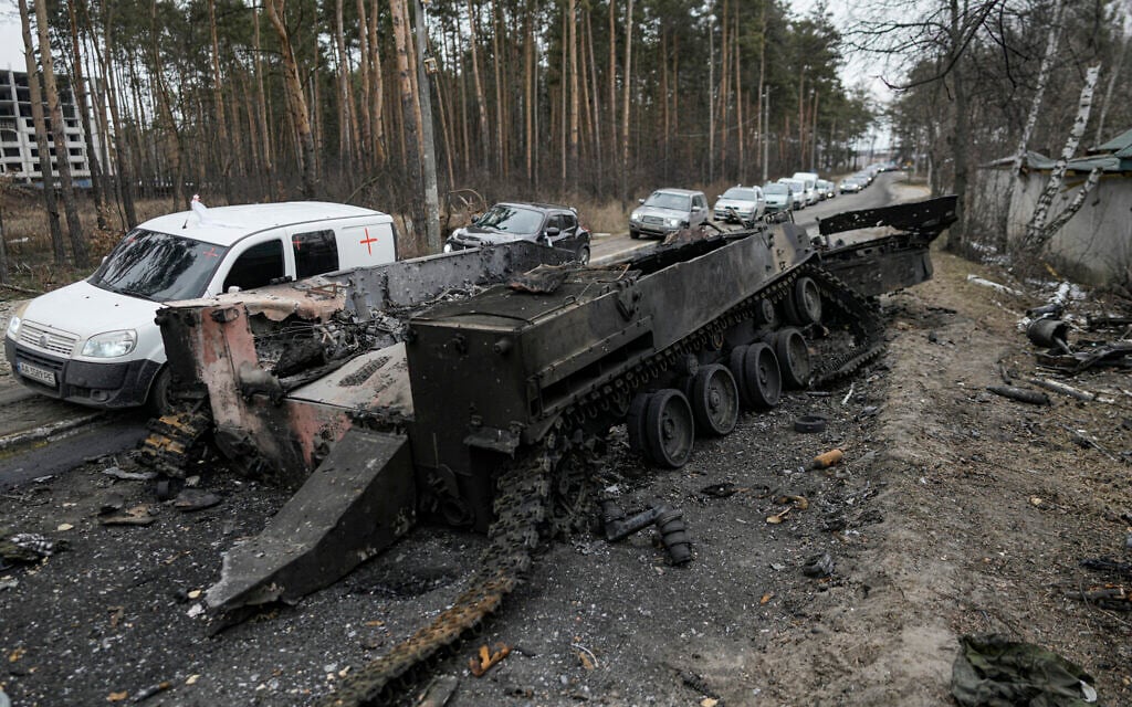 Cars drive past a destroyed Russian tank as a convoy of vehicles evacuating civilians leaves Irpin, on the outskirts of Kyiv, Ukraine, March 9, 2022. (Vadim GhirdaAP) Cars drive past a destroyed Russian tank as a convoy of vehicles evacuating civilians leaves Irpin, on the outskirts of Kyiv, Ukraine, March 9, 2022. (Vadim GhirdaAP)