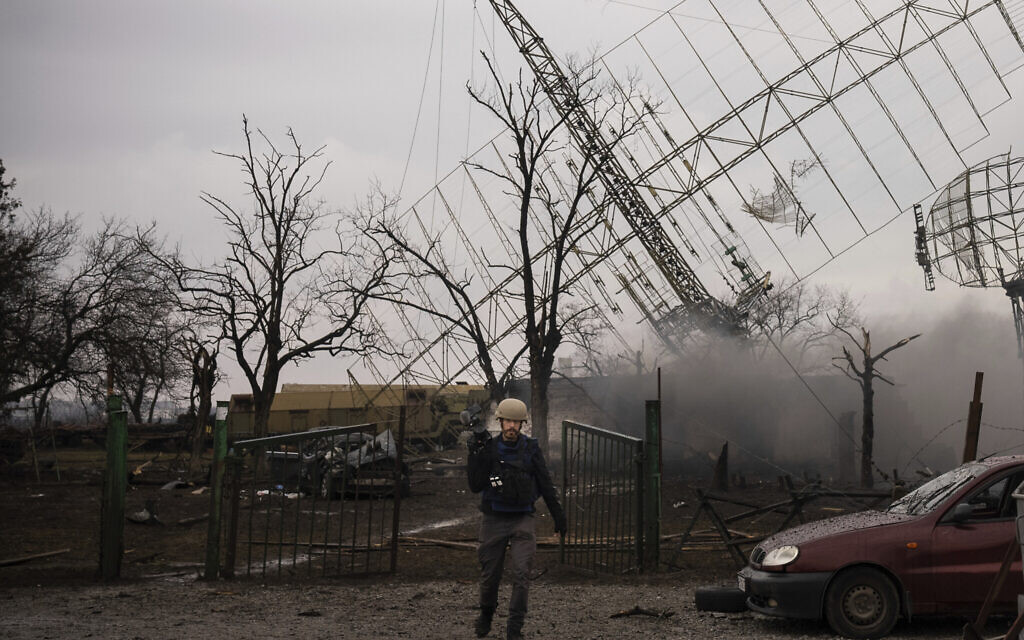 Associated Press videographer Mstyslav Chernov walks amid smoke rising from an air defense base in the aftermath of a Russian strike in Mariupol, Ukraine,  Feb. 24, 2022. (Evgeniy Maloletka/AP)