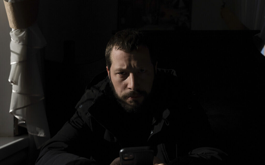 Associated Press videographer Mstyslav Chernov reads news on his phone three days before the start of Russian invasion in Volnovakha, Ukraine, Feb. 21, 2022. (Evgeniy Maloletka/AP)