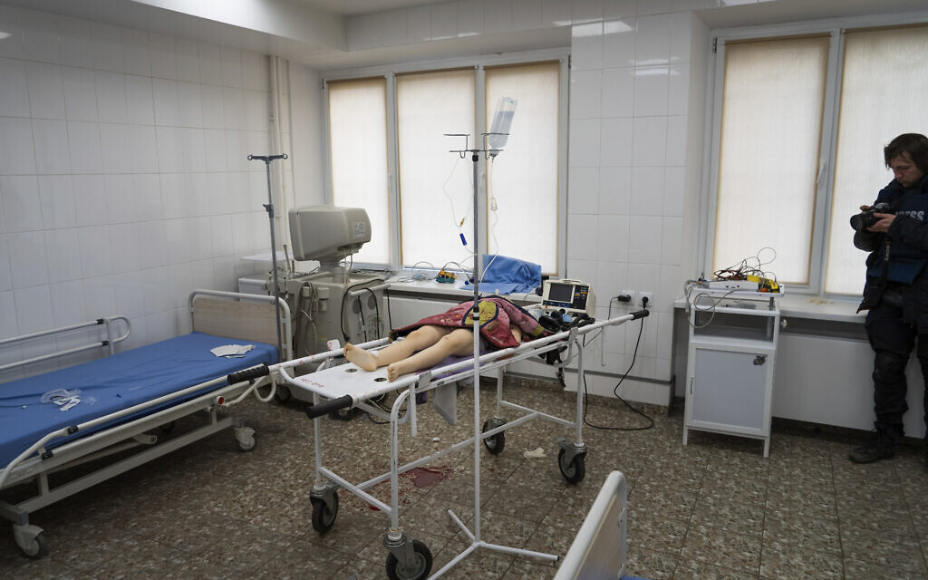 Associated Press photographer Evgeniy Maloletka takes a photo of the lifeless body of a girl killed during the shelling of a residential area at the city hospital of Mariupol, eastern Ukraine, Feb. 27, 2022. (Mstyslav Chernov/AP)