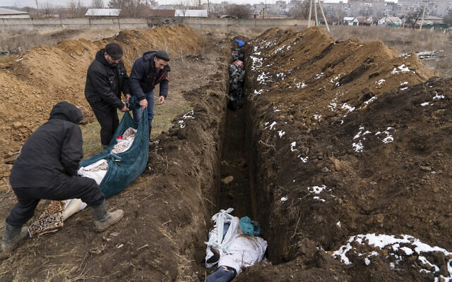 Dead bodies are placed into a mass grave on the outskirts of Mariupol, Ukraine, as people were unable to bury their dead because of heavy shelling by Russian forces, March 9, 2022. (Mstyslav Chernov/AP) Dead bodies are placed into a mass grave on the outskirts of Mariupol, Ukraine, as people were unable to bury their dead because of heavy shelling by Russian forces, March 9, 2022. (Mstyslav Chernov/AP)