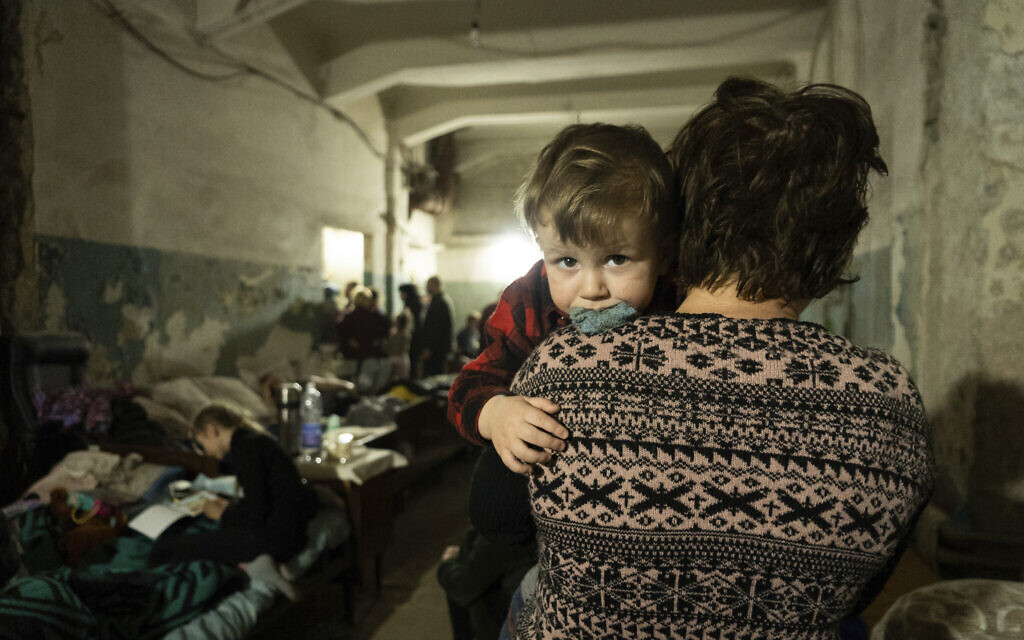 A woman holds a child in an improvised bomb shelter in Mariupol, Ukraine, March 7, 2022. (Mstyslav Chernov/AP)