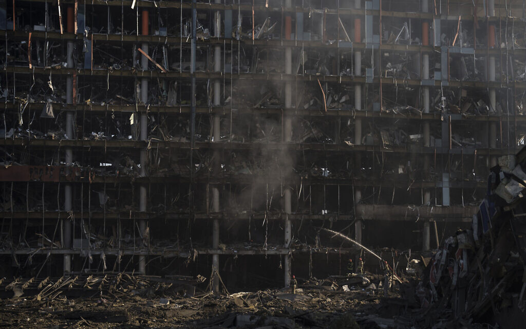 Firefighters extinguish a fire at a shopping center following a bombing in Kyiv, Ukraine, March 21, 2022. (AP Photo/Felipe Dana)