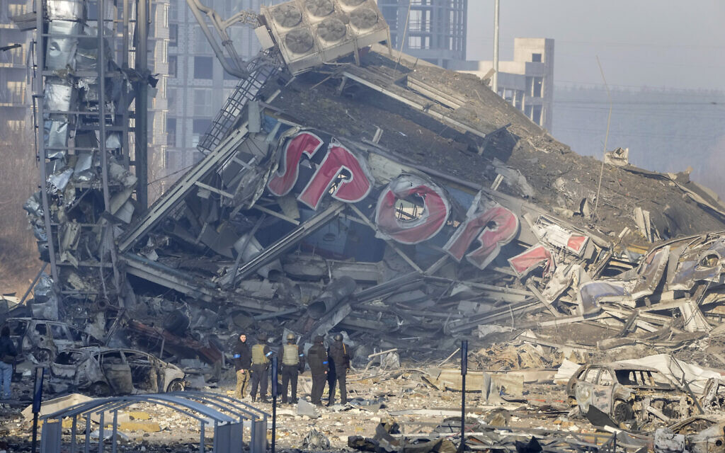 People examine the damage after shelling of a shopping center, in Kyiv, Ukraine, Monday, March 21, 2022. Eight people were killed in the attack. (AP/Efrem Lukatsky)