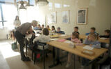 Ukrainian teacher Tatyana Gubskaya, center, teaches a class of children from Ukraine in Berlin, Germany, March 21, 2022. (AP Photo/Markus Schreiber)