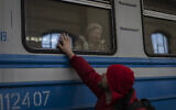 Displaced Ukrainians on a Poland-bound train bid farewell in Lviv, western Ukraine, March 22, 2022 (AP Photo/Bernat Armangue)