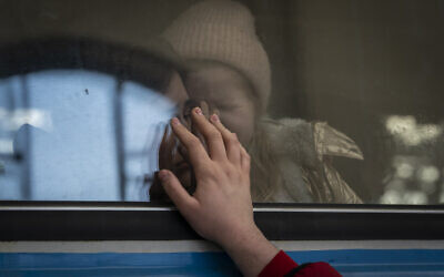 Displaced Ukrainians on a Poland-bound train bid farewell in Lviv, western Ukraine, March 22, 2022. (AP Photo/Bernat Armangue)