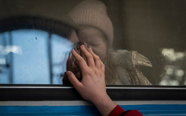 Displaced Ukrainians on a Poland-bound train bid farewell in Lviv, western Ukraine, March 22, 2022. (AP Photo/Bernat Armangue)