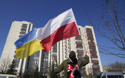 A man waves the Ukrainian and Polish flag during a demonstration in front of a building housing Russian diplomats in Warsaw, Poland, March 13, 2022. (AP Photo/Czarek Sokolowski, File)