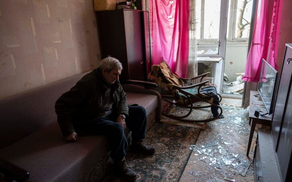 Volodymyr, 80, rests inside his apartment damaged by shelling, in Kyiv, Ukraine, March 23, 2022. (AP Photo/Rodrigo Abd)