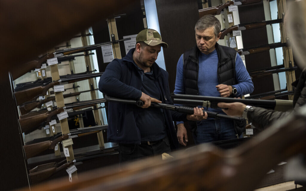 Ukrainians check rifles in a gun shop in Lviv, western Ukraine, March 23, 2022. (AP Photo/Bernat Armangue)