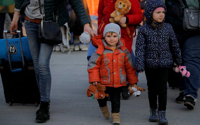 A refugee fleeing the war from neighbouring Ukraine walks with children holding toys after crossing the border by ferry at the Isaccea-Orlivka border crossing in Romania, on Thursday, March 24, 2022. (AP Photo/Andreea Alexandru) A refugee fleeing the war from neighbouring Ukraine walks with children holding toys after crossing the border by ferry at the Isaccea-Orlivka border crossing in Romania, on Thursday, March 24, 2022. (AP Photo/Andreea Alexandru)