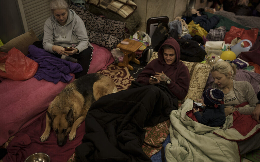 A family stays inside a subway station, being used as a bomb shelter, as Russian attacks continue in Kharkiv, Ukraine, March 25, 2022. (AP Photo/Felipe Dana)