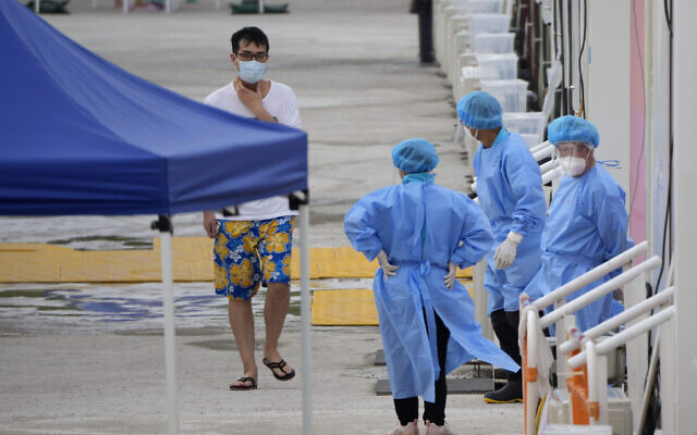 A patient, left, walks past mobile cabins COVID-19 isolation facilities in the San Tin area of Hong Kong, March 26, 2022. (AP Photo/Kin Cheung) A patient, left, walks past mobile cabins COVID-19 isolation facilities in the San Tin area of Hong Kong, March 26, 2022. (AP Photo/Kin Cheung)