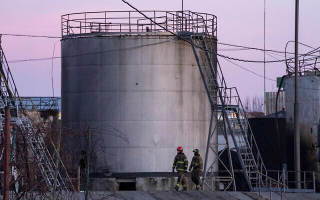 Firefighters work at the site in the aftermath of the first strike that involved Russian rockets that hit an oil facility in an industrial area in the northeastern outskirts of Lviv, Ukraine, March 27, 2022. (AP Photo/Nariman El-Mofty)