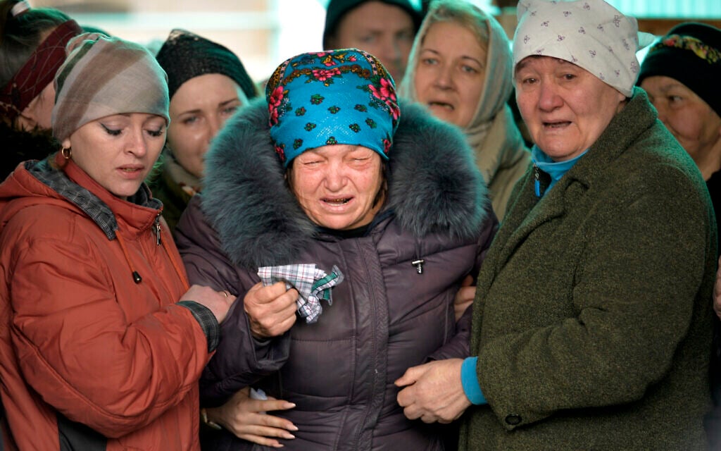 The mother of Russian Army soldier Rustam Zarifulin, who was killed fighting in Ukraine, center, cries surrounded by relatives during a farewell ceremony in his homeland in Kara-Balta, 60 km (37 miles) west of Bishkek, Kyrgyzstan, March 27, 2022. (AP Photo/Vladimir Voronin)