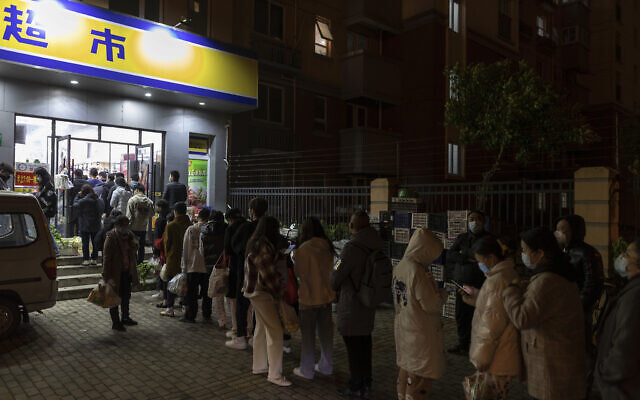 Residents wearing face masks to help protect from the coronavirus line up outside a supermarket at night to buy groceries on Sunday, March 27, 2022, in Shanghai, China. China began locking down most of its largest city of Shanghai on Monday as part of its strict COVID-19 strategy, amid questions over the policy's economic toll on the country. (AP Photo) Residents wearing face masks to help protect from the coronavirus line up outside a supermarket at night to buy groceries on Sunday, March 27, 2022, in Shanghai, China. China began locking down most of its largest city of Shanghai on Monday as part of its strict COVID-19 strategy, amid questions over the policy's economic toll on the country. (AP Photo)