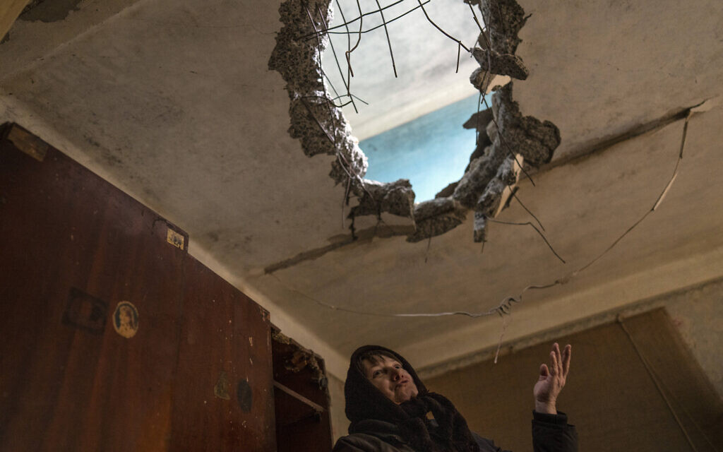 Halyna Falko, 52, talks to reporters while looking at the destruction caused after a Russian attack inside her house near Brovary, on the outskirts of Kyiv, Ukraine, March 28, 2022. (AP Photo/Rodrigo Abd)