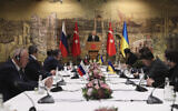 In this photo provided by Turkish Presidency, Turkish President Recep Tayyip Erdogan, center, gives a speech to welcome the Russian, left, and Ukrainian delegations ahead of their talks, in Istanbul, Turkey, March 29, 2022. (Turkish Presidency via AP)