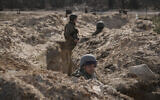 Ukrainian servicemen stand in trenches at a position north of the capital Kyiv, Ukraine, Tuesday, March 29, 2022. (AP/Vadim Ghirda)